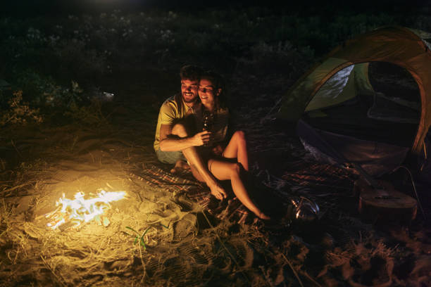 istock Loving couple drinking wine on camping night at the beach. 2154087077