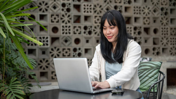 istock A young positive Asian woman is working remotely at a cafe, working on her laptop computer. 2154087104