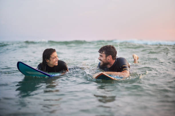istock Happy couple talking on surfboards at sea. 2154087133