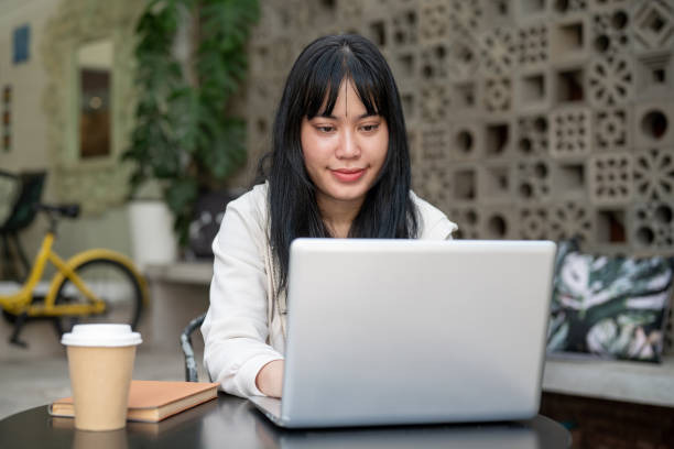 istock A young positive Asian woman is working remotely at a cafe, working on her laptop computer. 2154087151