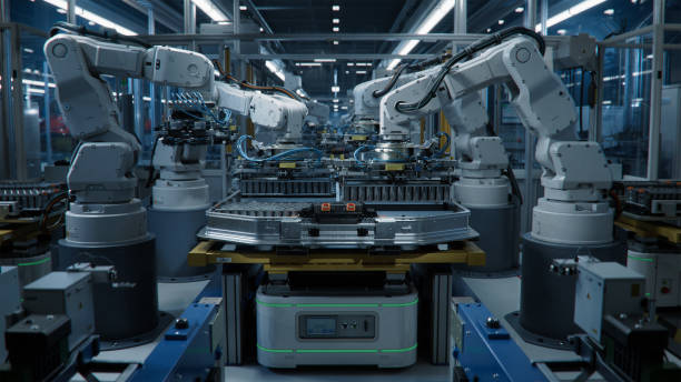 istock Front View of Industrial Robot Arms Assemble Lithium-Ion EV Battery Pack Inside Automotive Smart Factory. White Robotic Arms at Automated Production Line. Electric Car Manufacturing Line. 2154089150