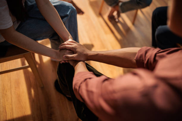 Consoling at therapy Man and woman holding hands during psychologist meeting about mental health. nervous holding hands stock pictures, royalty-free photos & images