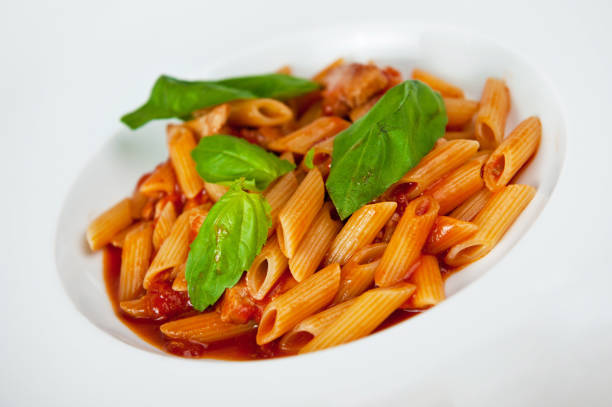 Fresh pasta macaroni with vegetables and spices on white background