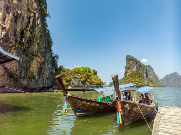 Traditional longtail boats rest nearby, completing the postcard-perfect image of this unforgettable island destination.