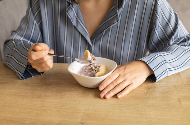 istock young woman eats granola with yogurt and bananas for breakfast 2154102163