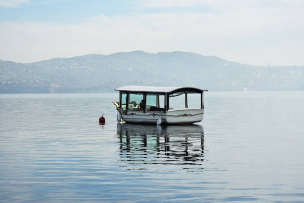 Empty tourboat on the sea or lake surface with mountain and sky background