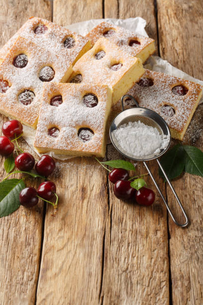 istock Bublanina pie fresh, juicy summer cherry enveloped in a soft sponge cake closeup on the parchment. Vertical 2154105870
