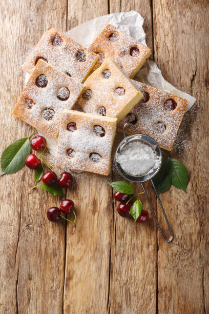 istock Bublanina pie fresh, juicy summer cherry enveloped in a soft sponge cake closeup on the parchment. Vertical top view 2154105941