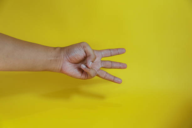 istock Open palm isolated on yellow background, Count three with finger 2154107357