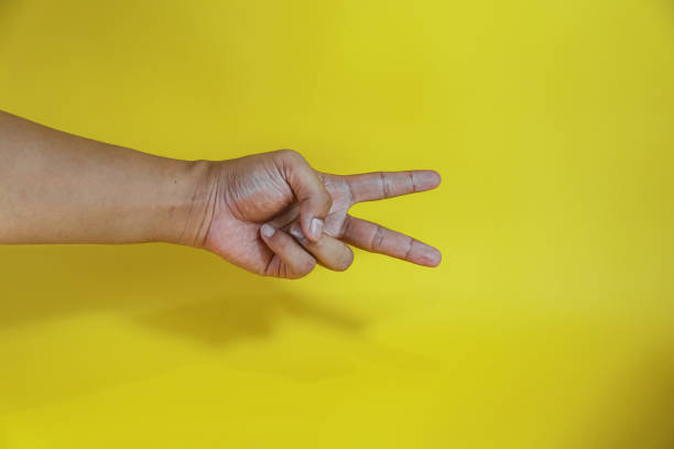istock Open palm isolated on yellow background, Count two with finger 2154107364