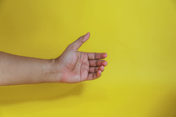 istock hand holding something like a bottle isolated on yellow background 2154107392