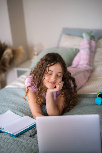 istock Girl using laptop on a bed in the morning 2154108556
