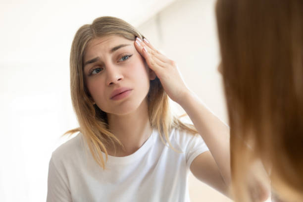 istock Woman with problem skin looking in the mirror 2154108686