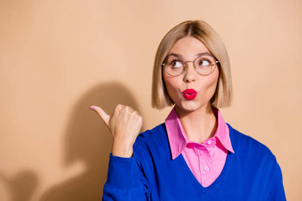 istock Portrait of impressed pretty lady pouted lips look direct finger empty space ad isolated on beige color background 2154109089