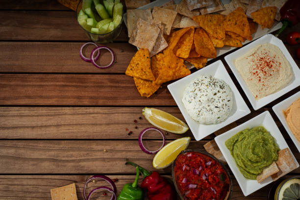 Top Down View of Wooden Table with Dips and Crackers