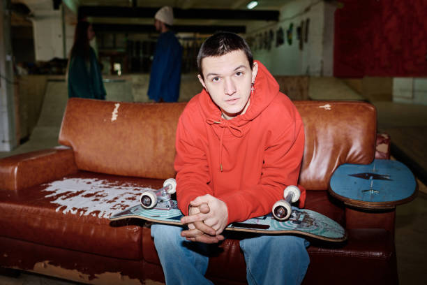 istock Young Man Sitting On Couch In Skatepark 2154110142