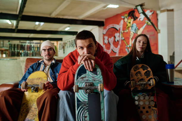 istock Gen Z Guy And His Friends With Skateboards 2154110265