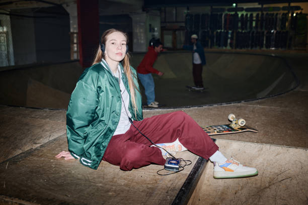 istock Young Woman Sitting On Floor In Skatepark 2154111026