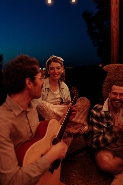 istock Three friends enjoying acoustic guitar music 2154111191
