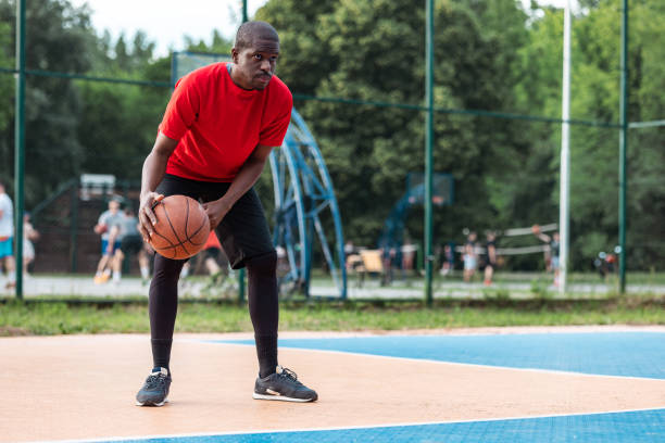 istock Man playing basketball outdoors on a sunny day 2154111564