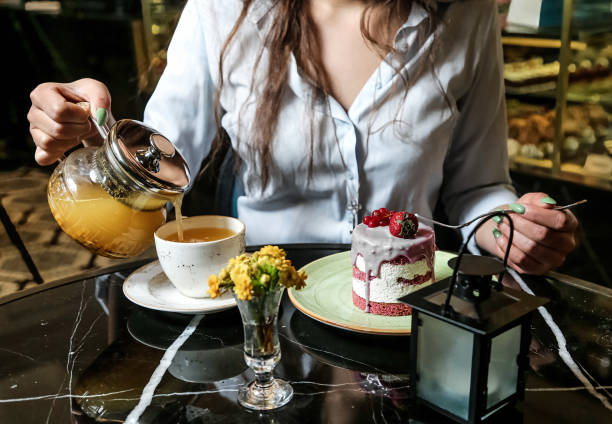 istock Woman Pouring Tea From a Teapot Into a Cup 2154112415