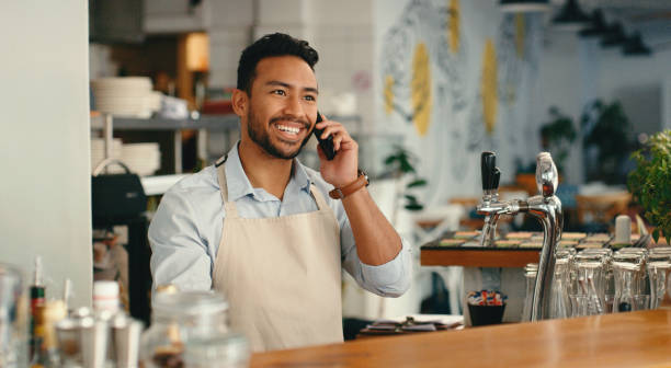 istock Waiter, man and phone call in cafe for order, customer support and communication for takeaway. Small business, barista and smartphone in coffee shop with online management, digital sale and ecommerce 2154114132