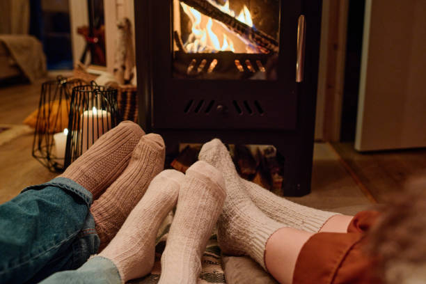 istock Unrecognizable Family Relaxing In Front Of Fireplace 2154116127