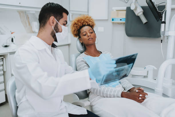 istock Dentist explaining dental X-rays to a patient 2154116592