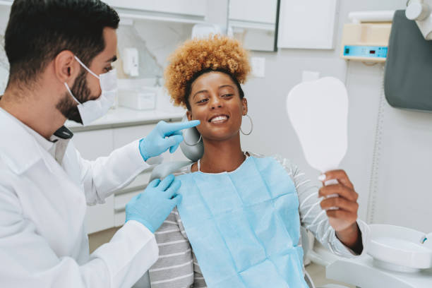 istock Woman at dentist holding mirror 2154116624