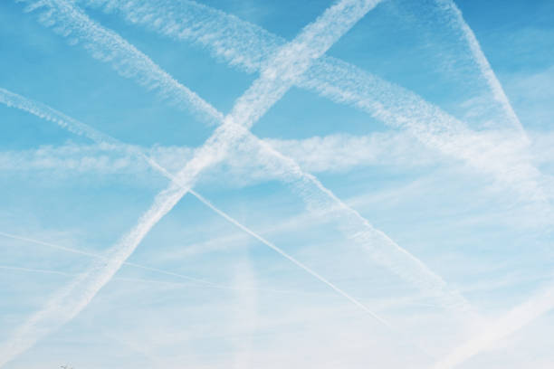 istock Airplane condensation trail with lines of clouds over blue sky background. 2154118569