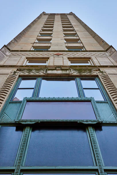 istock Upward view of side of skyscraper building with windows reflecting blue sky, fun architecture 2154121934