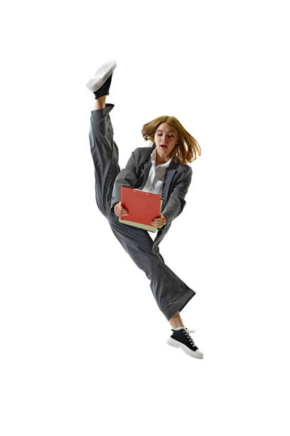 istock Dynamic Professionalism. Businesswoman performing high kick in motion and holding folder against white studio background. 2154122298