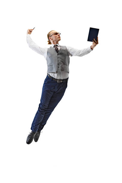 istock Young man dressed smart casual outfit and gracefully jumps and using tablet against white studio background. 2154122303