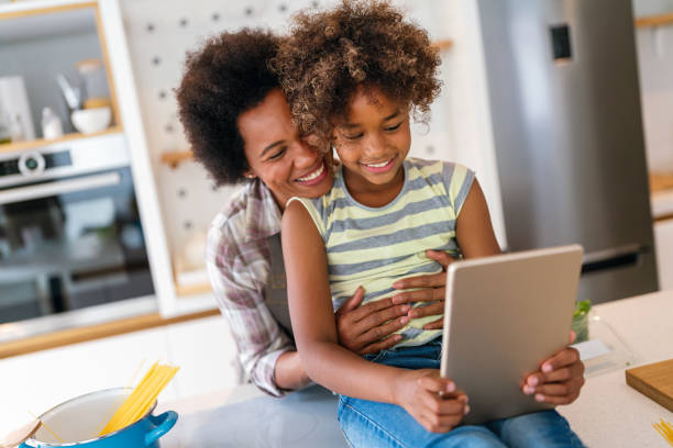 istock African american mother and daughter with tablet pc computer doing homework together at home 2154123225