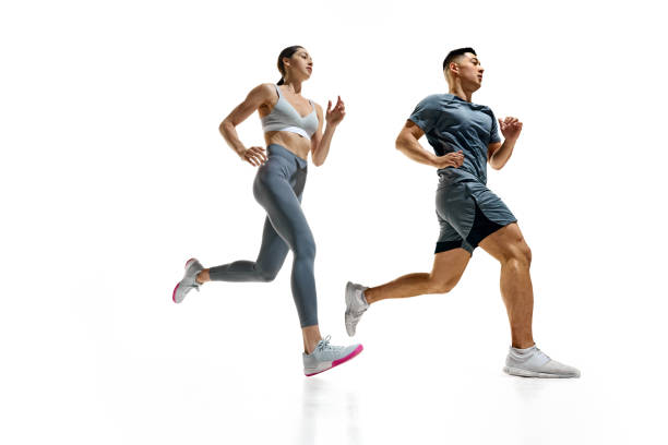istock Two athletes sprinting, captured in moment of peak effort against white studio background. Synchronized movement 2154124702