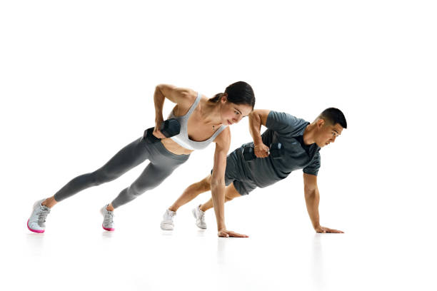 istock Dynamic image of fit man and woman performing plank row exercise with dumbbells against white studio background. 2154124751