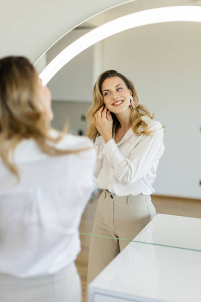 Young woman getting ready in front of a mirror