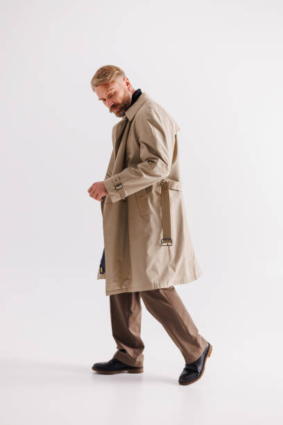 istock Blonde haired and bearded man in classic coat walking on gray background 2154131980
