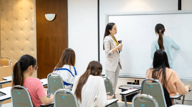 istock A woman is teaching a class of students in a classroom 2154135224