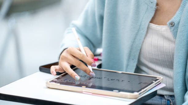 istock A woman is writing on a tablet with a pen 2154135415