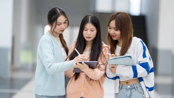 istock Three women are standing in a hallway, each holding a tablet 2154135477