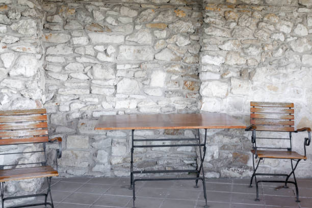 chairs and a table against the background of a stone wall