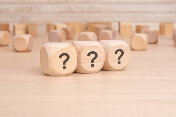 istock three wooden blocks with question marks over a brown background with copy space 2154136518