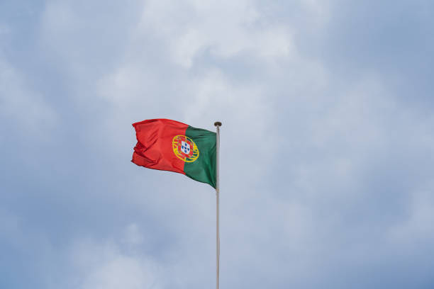 istock Portuguese flag on a flagpole against the sky with storm clouds. 2154144271