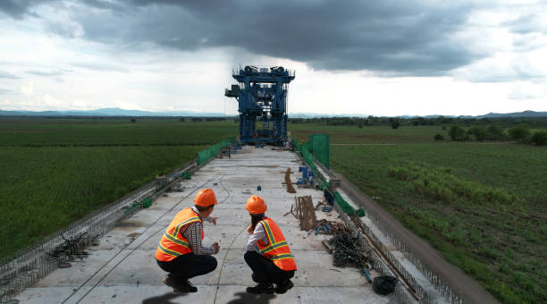 Two road engineers working on the pillar of a New highway bridge under construction.Construction of the  concrete building's pillars using a crane