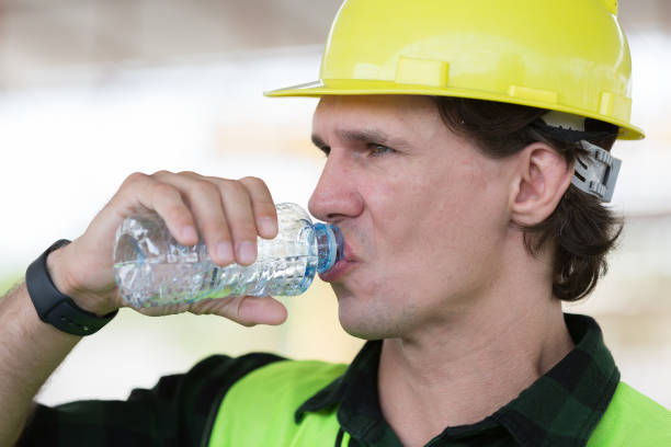 istock Male engineer drinking water at construction site. Male construction builder drinking water at site work 2154150287