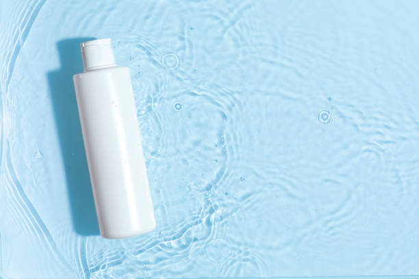 istock Cosmetic moisturizer with hyaluronic acid, micellar emulsion on blue water background with splashes. Mockup of cosmetic packaging 2154150936