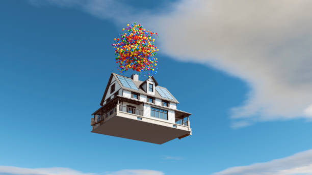 house floating in the sky, lifted by a large cluster of colorful balloons attached to its roof. The house is a typical residential building with solar panels on the roof, and it is surrounded by a clear blue sky with scattered clouds, creating a surreal and dreamlike atmosphere