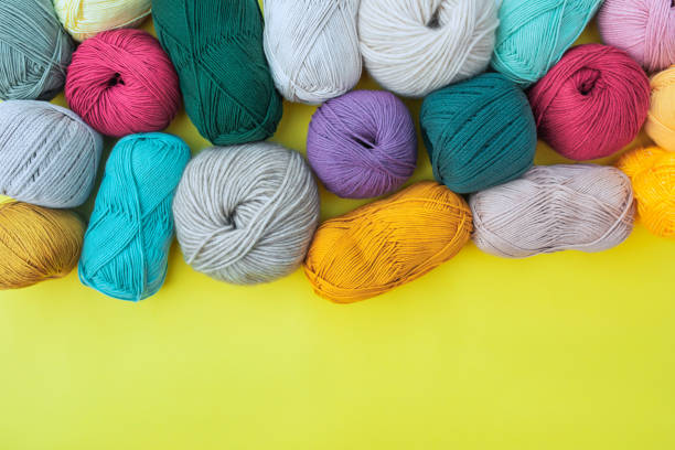 istock Multicolored fibers for hand made work on yellow background. 2154153413