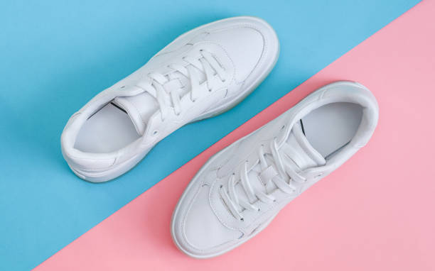 istock White sneakers on a blue-pink background. 2154153587